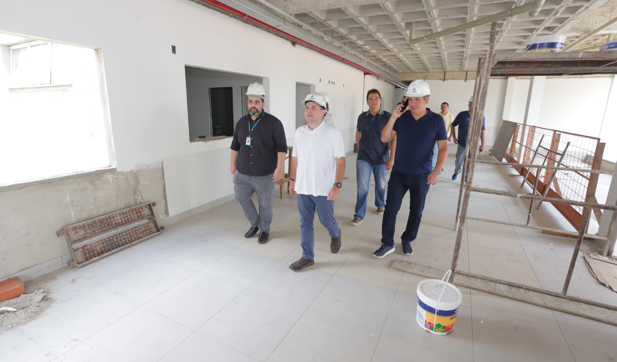 prefeito e homens ao lado andando em local em obras